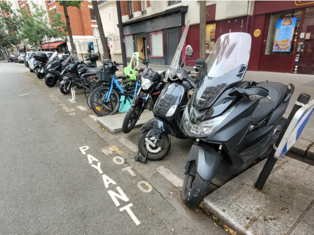 Stationnement gratuit à Paris : louez un 2-roues électrique 1 Rangée de motos à moteur thermique garés dans une rue de Paris. Stationnement payant.